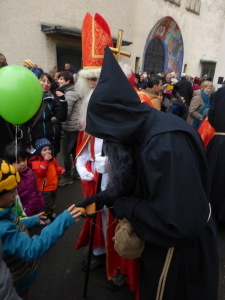 St. Nicholas and Knecht Ruprecht talk to a child in Wil, Switzerland.